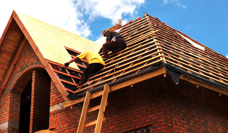 two roofers work