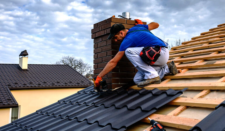 a blue t shirt wear man doing asphalt roofing