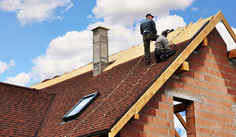 two roofers doing asphalt roofing services